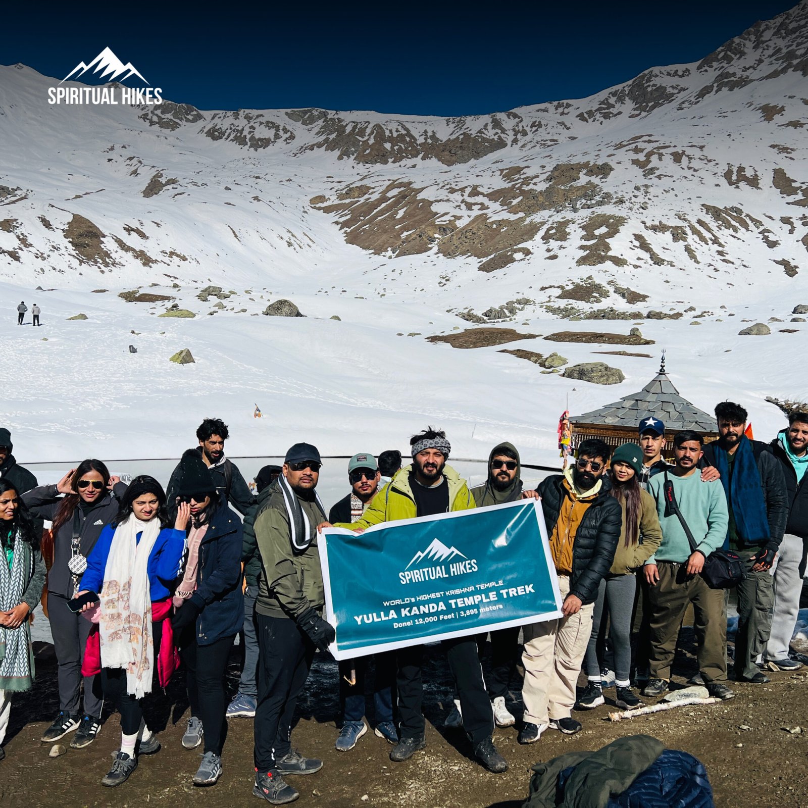 Trekkers at Yulla Kanda Temple Trek surrounded by snowy Himalayan mountains in Himachal Pradesh